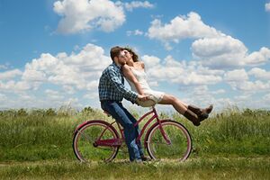 Weiterbildung Systemisch-integrale Paar- und Sexualberatung - ein glückliches Paar zusammen auf einem Fahrrad Weiterbildung Systemisch-integrale Paar- und Sexualberatung - ein glückliches Paar zusammen auf einem Fahrrad